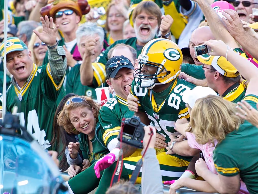 Foto de um Lambeau Leap com um jogador dos Packers pulando na arquibancada